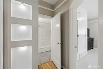 Hallway showing inset shelves leading into the bathroom and a bedroom.