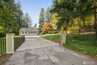 gated drive partially fences yard for pets.