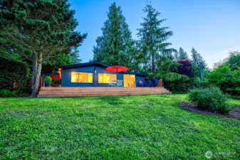 Bathed in twilight and wrapped in cedar, River House Retreat glows with rustic welcome. Set on a parklike half-acre framed by evergreens and birdsong, this 3BD/2BA getaway sleeps 8 and features a 600+ SF deck perfect for morning coffee, stargazing, and stories by starlight.