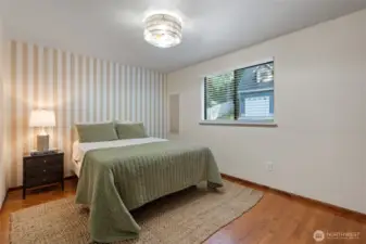 A spacious bedroom on the main floor, complemented by a nearby full bathroom, offers comfort, convenience, and privacy all in one.