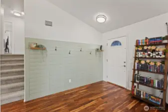 Gorgeous shiplap accent wall with coat hooks just inside the front door.