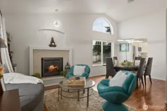 Formal living room with cozy gas fireplace opens up to formal dining area.