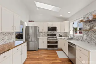 Newer stainless steel appliance, counter tops, sink and tiling make this kitchen a stunning place to gather.
