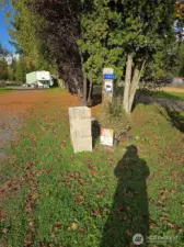 Gravel road entry to the property and storage building and carport.