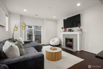 Feature wall showcasing the fireplace and media setup, with balcony access nearby