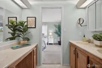 Ensuite bathroom has a two sink countertop along with a vanity on the other wall. There is also a large walk-shower.