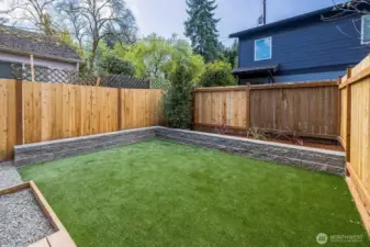 Artificial turf grass installed with garden space and western exposure.