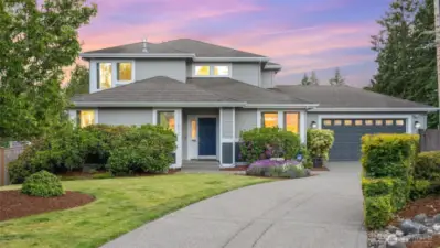 Mature and colorful landscaping lines the long driveway