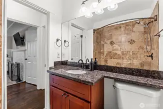 Updated Bath with Granite Counters, Stone Tile Surround, and Warm Wood Vanity