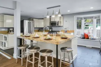 A well-appointed open kitchen boasts of a huge center island with bar counter seating, perfect for entertaining.