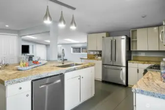 Gorgeous granite countertops are highlighted by stainless steel appliances and pendant lighting.
