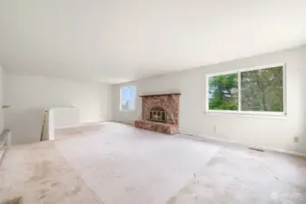 Living room with brick wood burning fireplace.