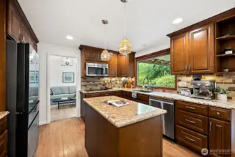 The kitchen is a chefs dream with stainless steel appliances, updated wood cabinets, double oven, granite countertops and prep island.