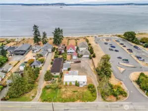 The area view with Puget Sound out front and the property from the road. It extends to the fence about half way up the lots this side of the red truck.