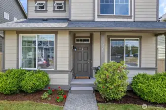 AS one approaches the front door, there's a covered outdoor deck, another place to relax with outdoor chairs in place.