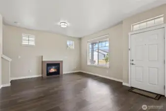 Notice windows, gas fireplace and entry door to the right