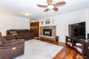 Here, the living room centers around a charming brick fireplace, adding warmth and character to the home. The spacious layout comfortably fits multiple seating options, making it ideal for movie nights or gatherings. The neutral walls and updated floors provide a clean backdrop for any design style, while the fireplace ensures a focal point that makes the room feel instantly welcoming.