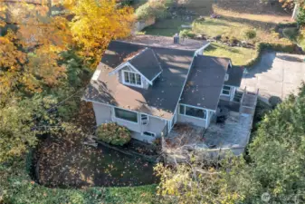 Aerial view of the home showing deck, front yard, and parking area.