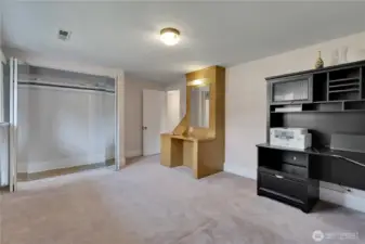 Large mirrored closet and built-in vanity that includes a laundry chute.