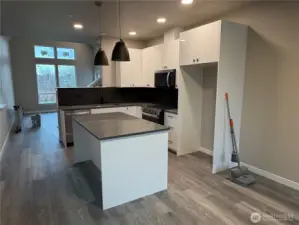 View of kitchen from front door looking towards the living area