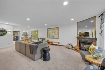 The living room lives large.  Can lighting, big picture window lots tons of light in and the wood burning fireplace ties the space together.