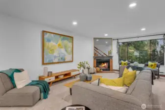 The living room lives large.  Can lighting, big picture window lots tons of light in and the wood burning fireplace ties the space together.
