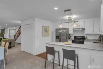 Kitchen with breakfast bar, quartz counter, subway tile back splash, new refrigerator and new lighting.  Solid wood cabinets will last for years to come.