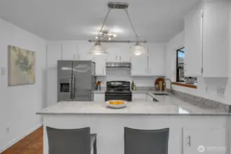 Great kitchen space for preparing meals. Lots of counter and cabinet space in this functional kitchen.  Deep stainless steel sink with garden window, new counters and subway tile backsplash. Dishwasher, stove, refrigerator with built in ice and water dispenser stay with.