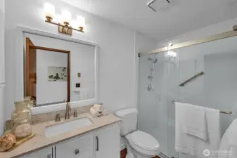 The attached primary bathroom with new lighting, new vanity and luxury step in shower.