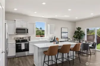 Large kitchen island with breakfast bar. Actual home is under construction. Colors, materials, and features may vary. See site agent for details.