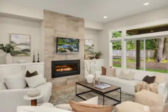 Spacious great room featuring a gas fireplace with tile surround, large picture windows, and an open-concept design perfect for everyday living and entertaining.