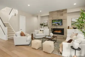 Open-concept living room with wide-plank hardwood floors, modern gas fireplace, and clean architectural lines—designed for comfortable everyday living and effortless entertaining.