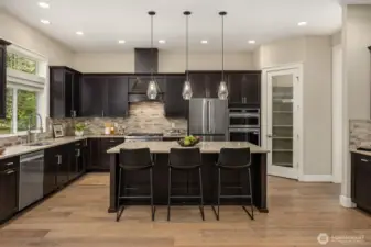 Gourmet kitchen with island seating, pendant lighting, walk-in pantry, and high-end finishes—modern design meets practical living on Bainbridge Island.