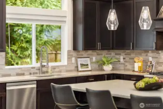 Chef’s kitchen with quartz countertops, tile backsplash, stainless steel appliances, and a window over the sink bringing in natural light and serene garden views.