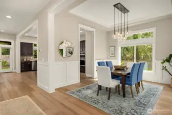 Bright, light-filled dining space with oversized windows, elegant modern lighting, and seamless flow to the kitchen.
