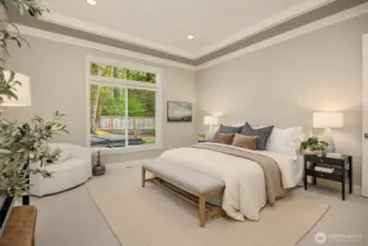 Spacious main-floor primary suite featuring a tray ceiling, serene backyard views, and a spa-inspired ensuite—designed for comfort, privacy, and easy single-level living.