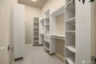 Custom walk-in closet with built-in shelving, drawers, and abundant hanging space for effortless organization.