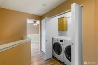 Upper floor laundry with newer washer and dryer.  To the left a linen closet.