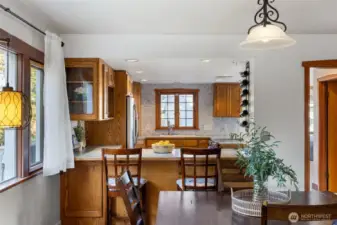 “Bright kitchen with a cozy breakfast nook surrounded by windows.”