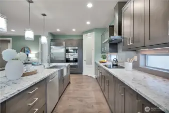 Spacious kitchen with room for more than one cook!  Wolf microwave/convection oven + standard convection oven below.  Wolf Induction Cook Top Range. Undercounter lighting as well as counter height windows.