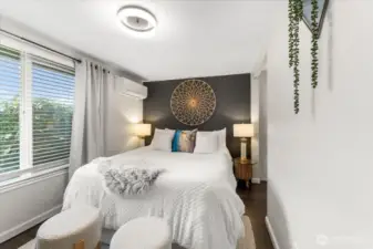 Abundant natural light flows through a generous picture window,brightening the bedroom.