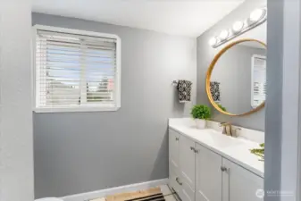 A decorative mirror above the vanity adds style and elegance to the bathroom.