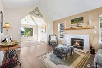 Living room compete with propane fireplace leading into dining room