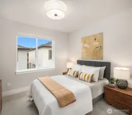 Bright and versatile bedroom space with large windows and modern finishes.