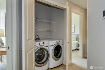 Laundry with full size washer and dryer plus storage.