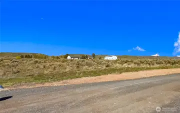 South West corner of the property, lot lines are approximately the fence line on other side of driveway.