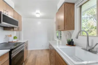 Sunny window above the sink overlooks woods setting outdoors