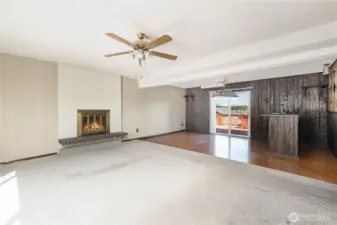 Spacious downstairs family room featuring a cozy fireplace & bar, perfect for gatherings and relaxation.