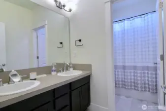 Upstairs bathroom. Dual vanity with a toilet and shower/tub combination.