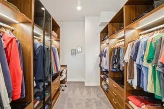 Spacious walk in closet with custom built ins and  desk area.